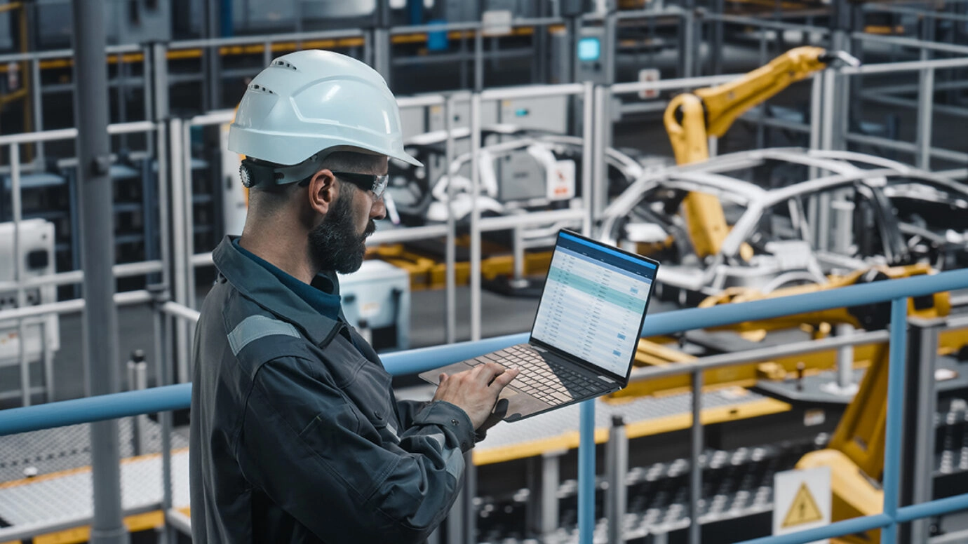 Worker wearing an helmet using a laptop